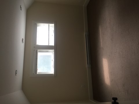 A window in a room with a white wall.