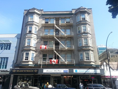 a tall building with balconies on a city street
