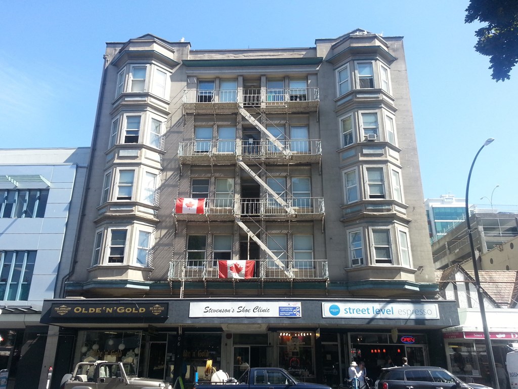 a tall building with balconies on a city street