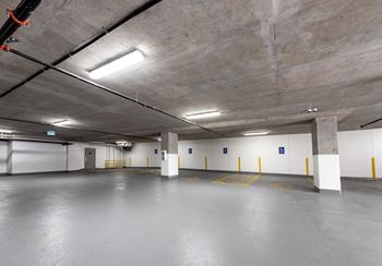 an empty parking garage with white walls and concrete floors