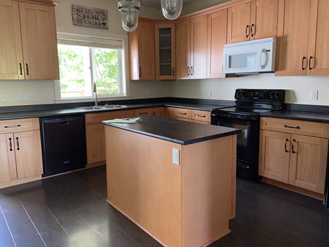 A kitchen with wooden cabinets and black appliances.