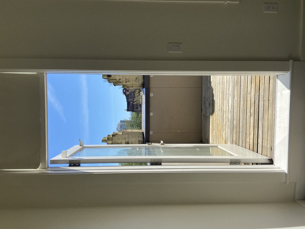 an open window with a view of a building in the distance