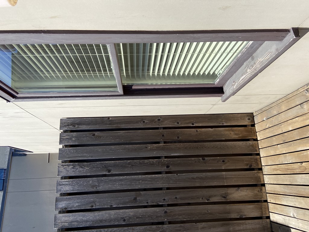 a view of the underside of the stairwell with a wood paneled wall and a glass