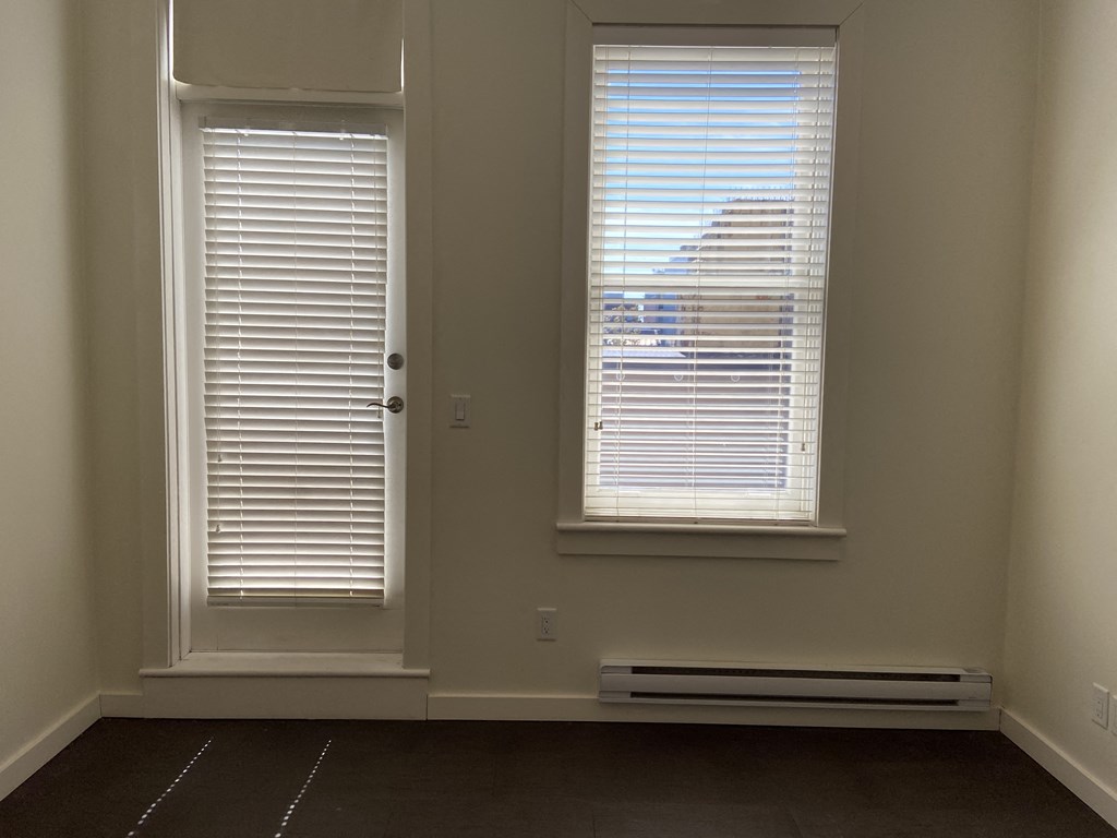 an empty room with two windows and a radiator