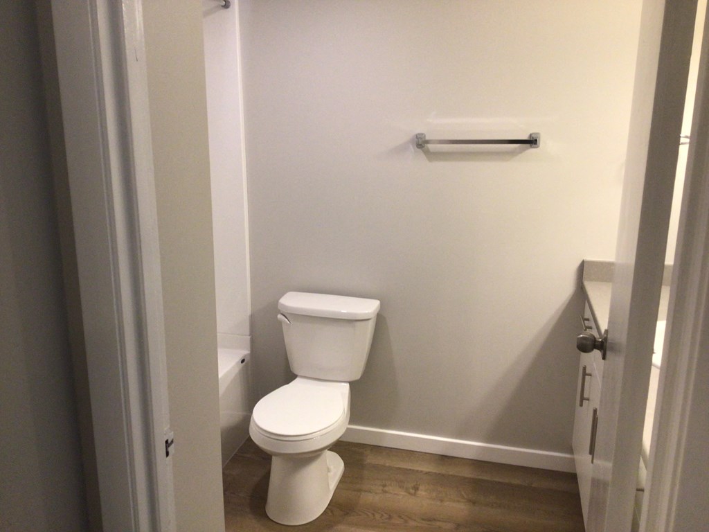 a white toilet sitting in a bathroom next to a towel rack