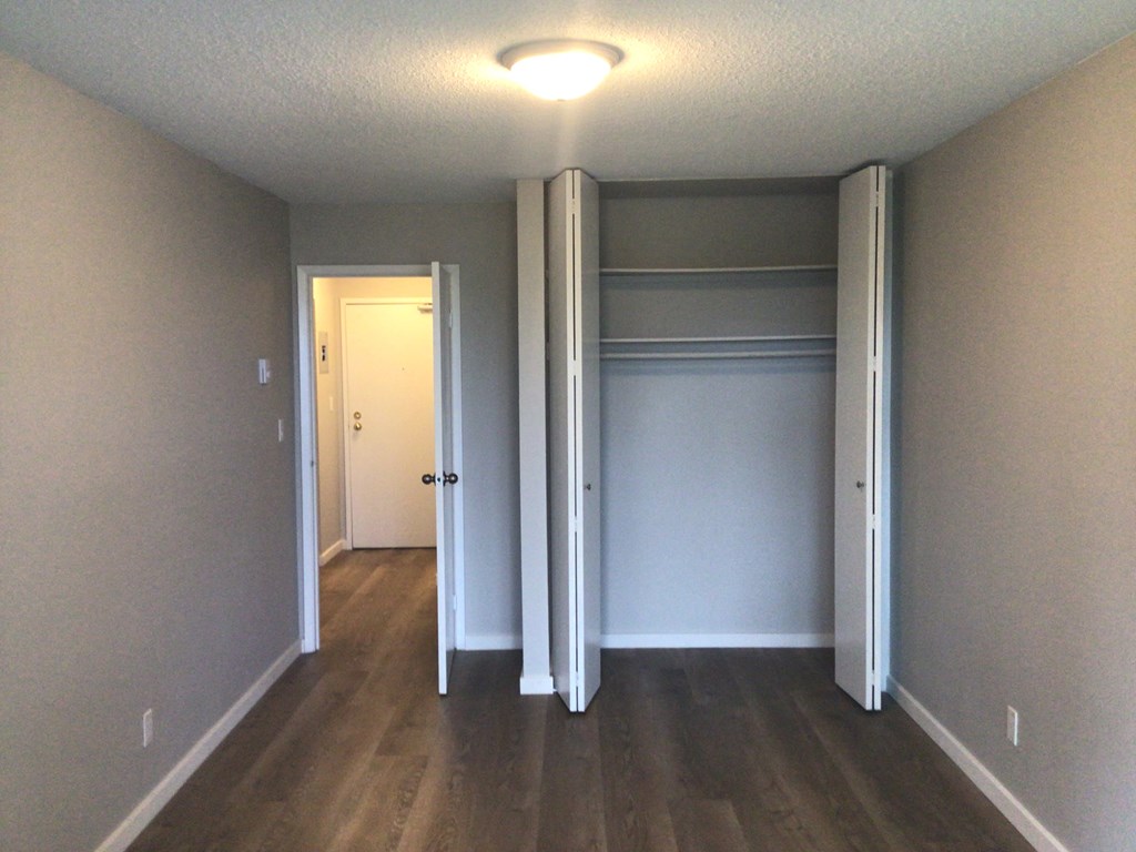 an empty room with a closet and a light on