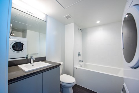 a bathroom with a toilet sink mirror and bathtub