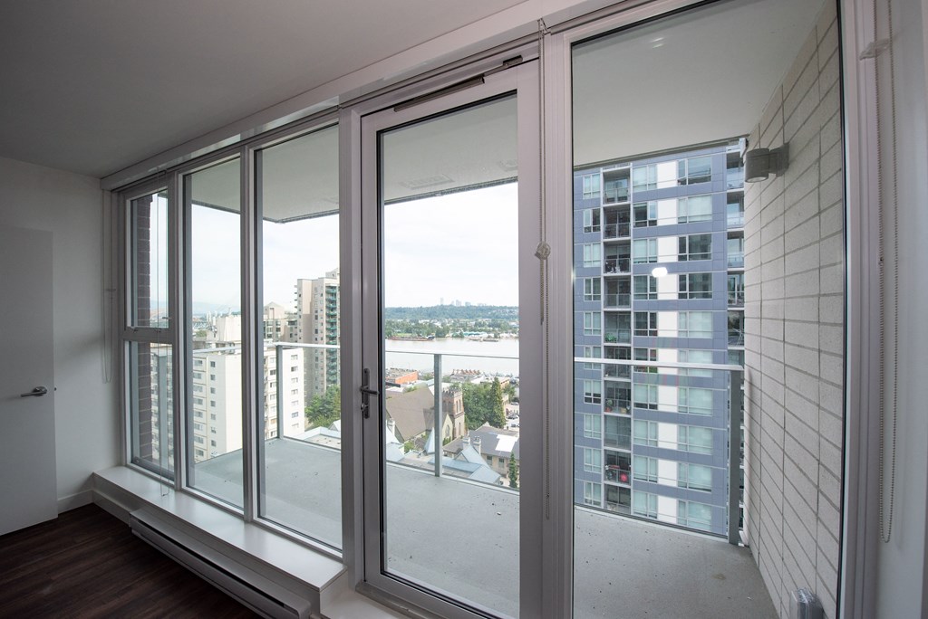 a bedroom with a large window and a balcony