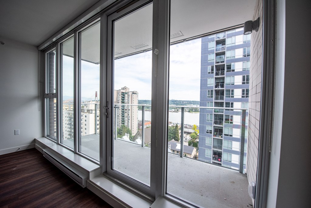 a bedroom with large windows and a balcony