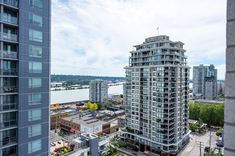 an aerial view of a tall building in a city with a river in the background