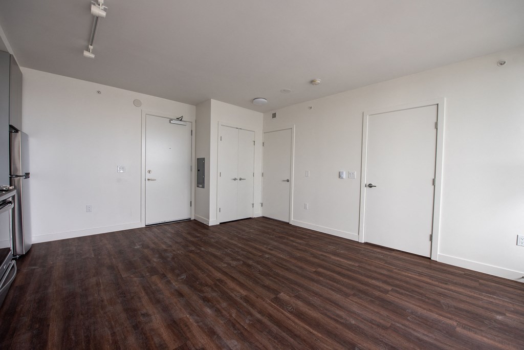 a bedroom with hardwood floors and white walls