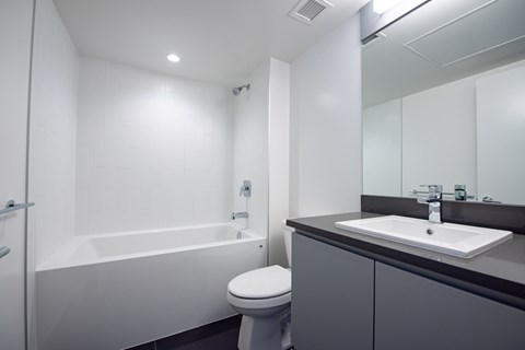 A white bathroom with a toilet, sink, and bathtub.