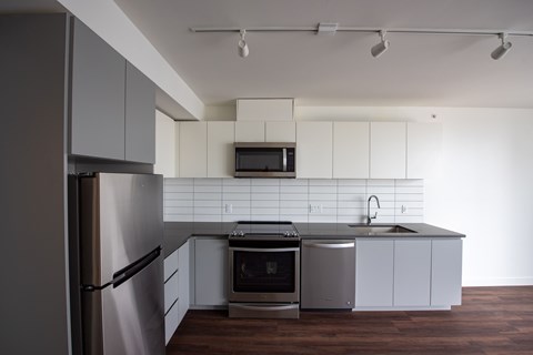 A modern kitchen with stainless steel appliances and white cabinets.
