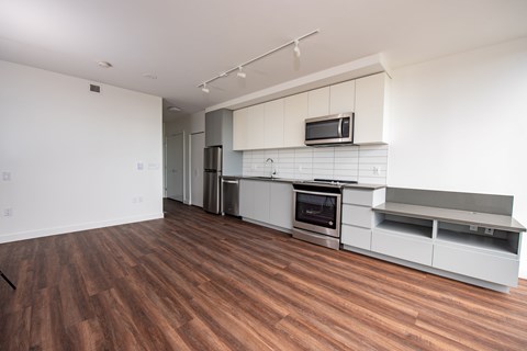 A kitchen with a wooden floor and white cabinets.