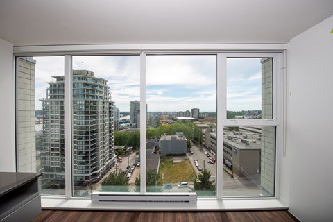 A room with a large window overlooking a cityscape.