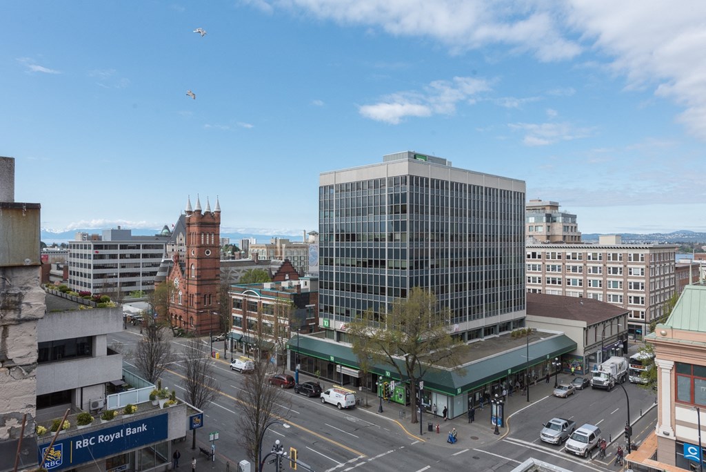 an overhead view of a city street with a large building and a tower in the background