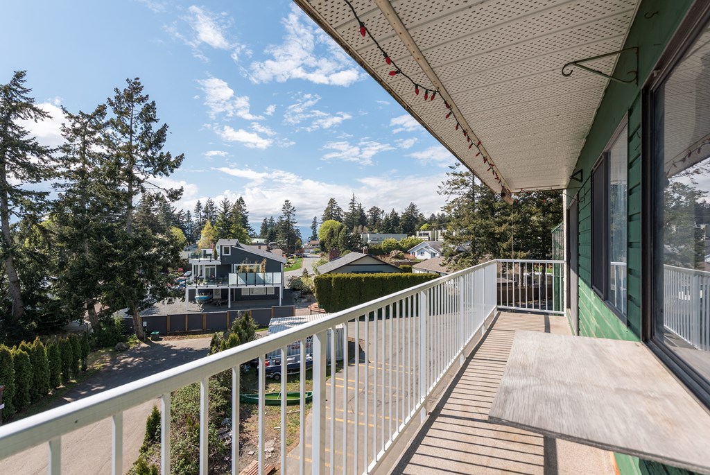 a balcony with a wooden bench and a view of a city