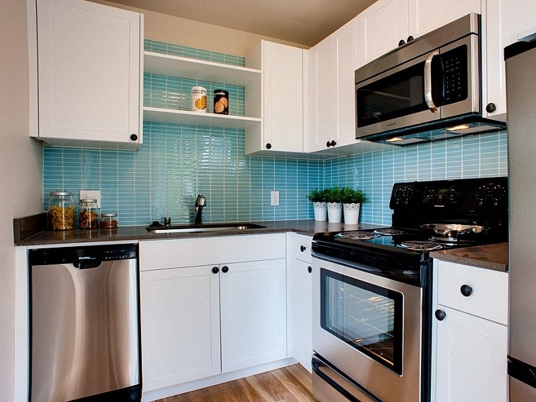 a kitchen with white cabinets and a stove and a sink
