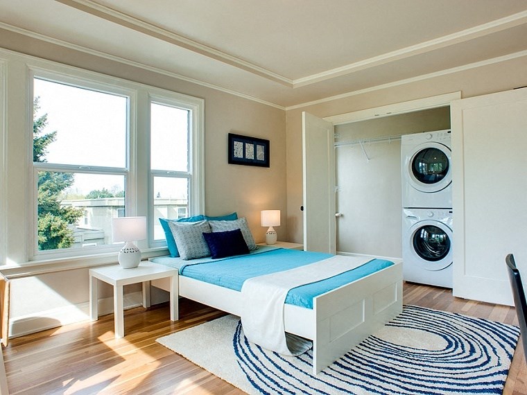 a bedroom with a bed and a washing machine