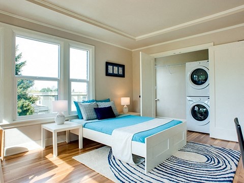 a bedroom with a bed and a washing machine