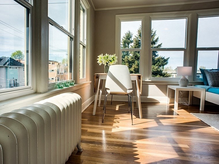 a living room with a radiator and a table with a chair