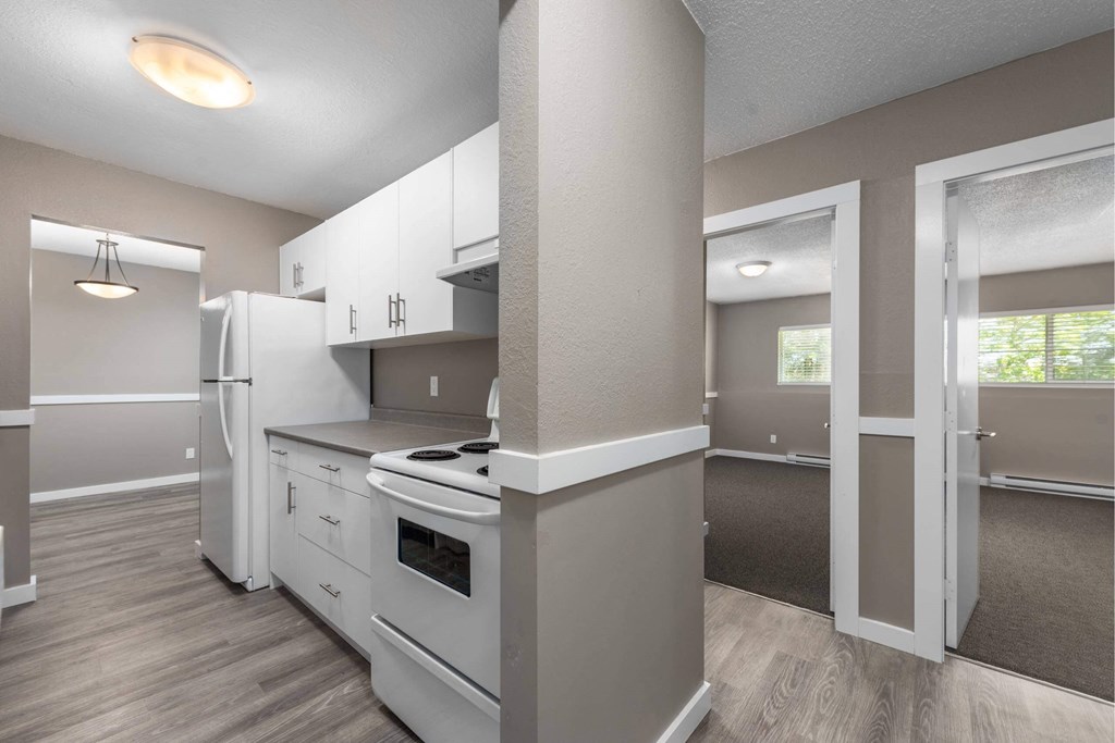 A kitchen with white appliances and cabinets.