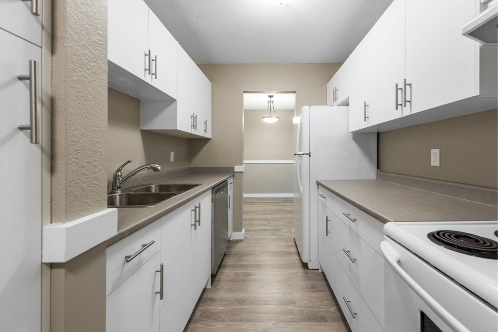 A kitchen with white cabinets and a stove top oven.