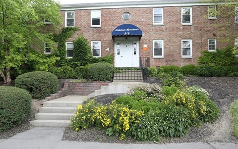 A brick building with a white door and a sign that says "Most Meeting".