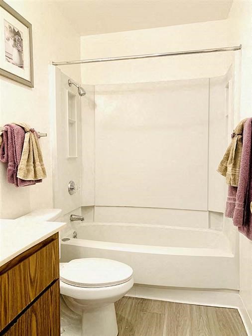 a white bathroom with a toilet and a shower