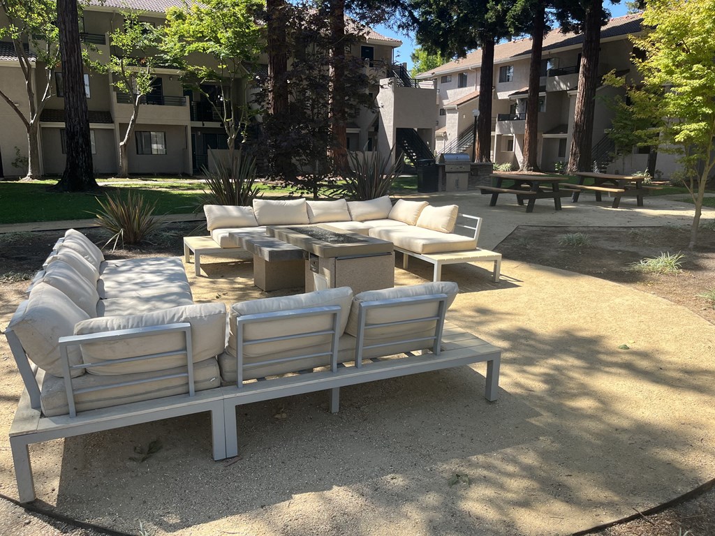 a seating area with couches and tables in a park