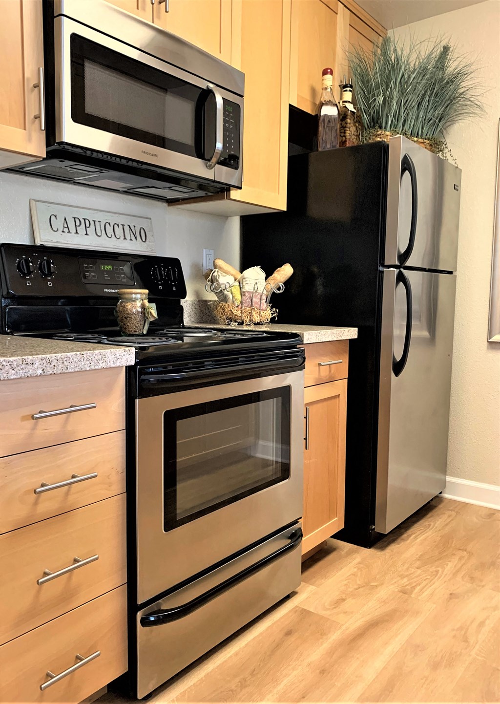 2 bedroom model  kitchen with black/stainless steel appliances such as refrigerator, microwave and stove/oven