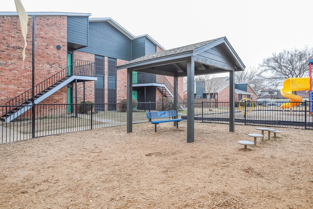 A playground with a blue bench and a yellow slide.