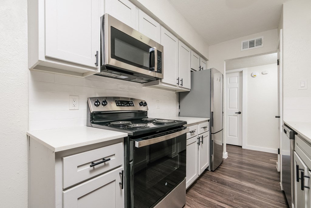 A kitchen with white cabinets and a black stove top oven.