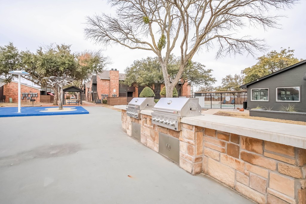 A patio with a brick wall and a blue mat.