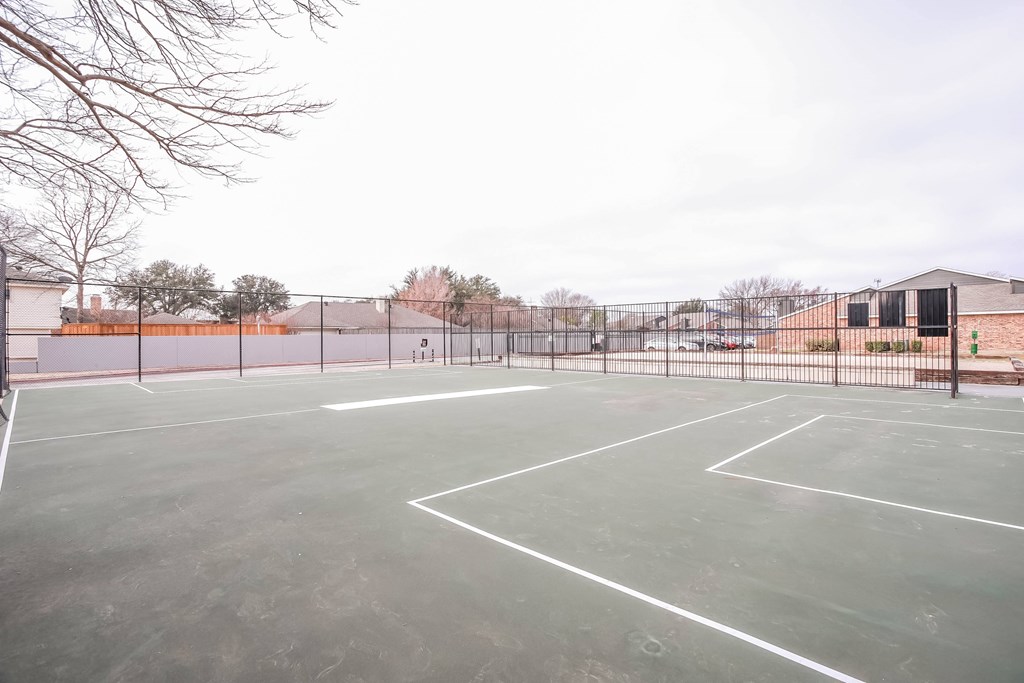 A tennis court with a fence surrounding it.