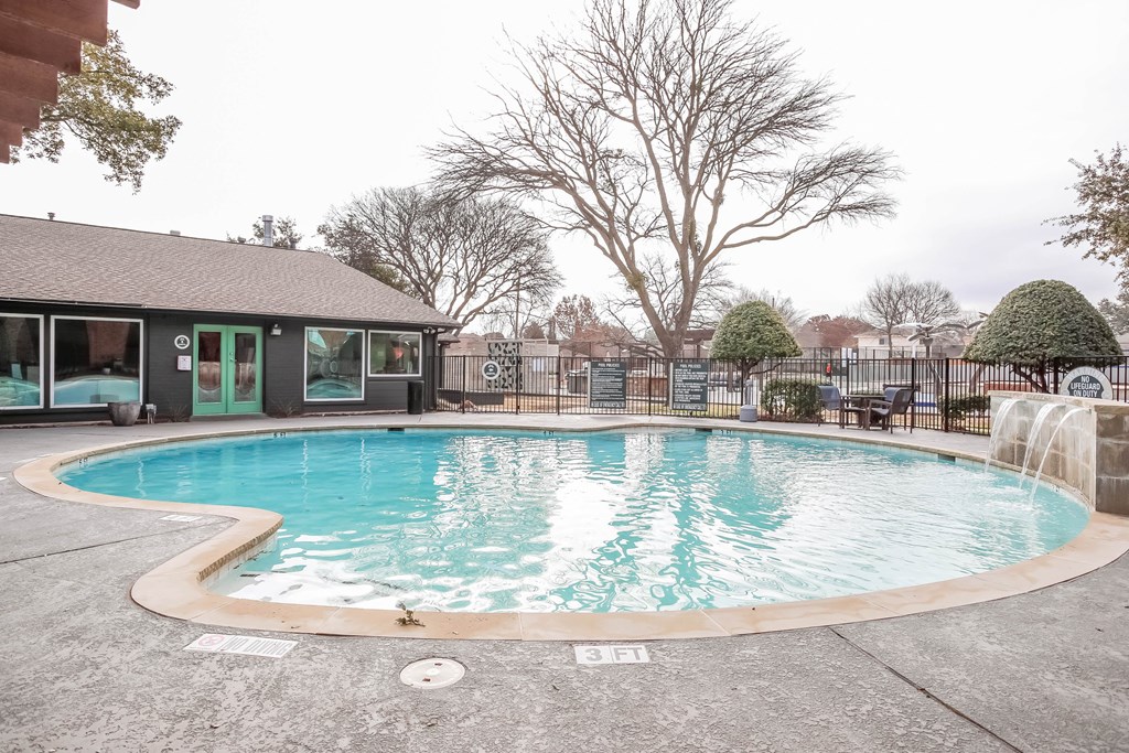 A round above ground pool with a concrete floor and a concrete wall surrounding it.