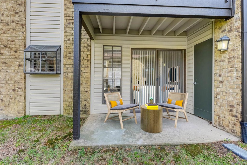 a patio with two chairs and a table on a porch