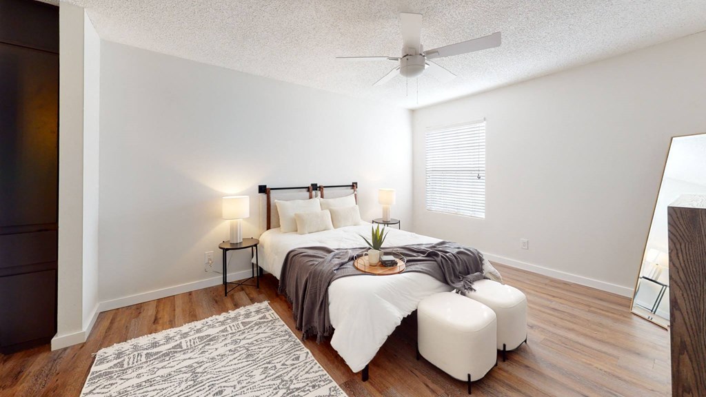 a bedroom with a bed and a ceiling fan