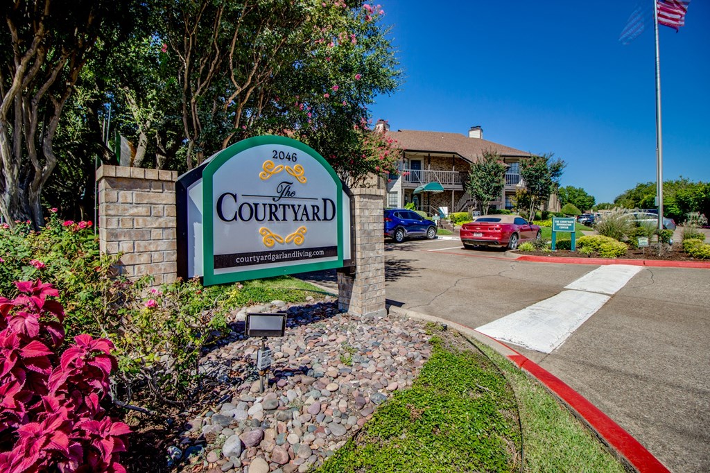 the sign at the entrance to the courtyard in front of a building