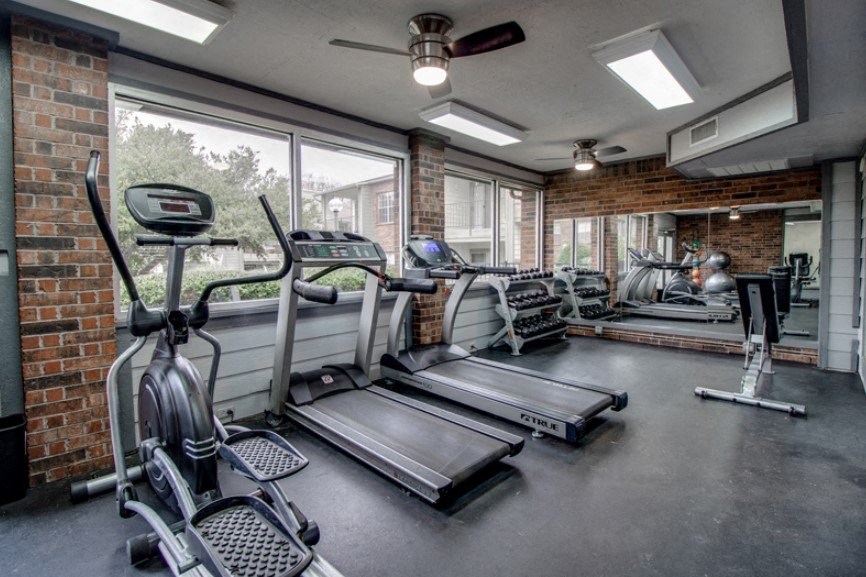 the gym has plenty of cardio equipment and a large window