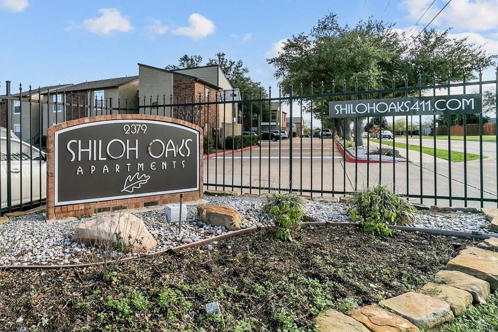 the sign for shoot oaks apartments in front of a gate