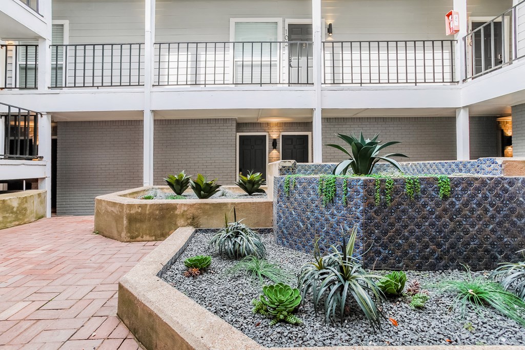 a courtyard with a fountain and plants at the bradley braddock road station apartments