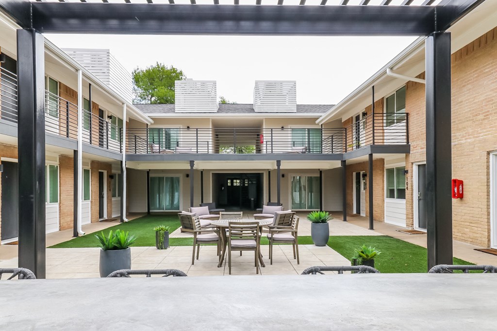 a patio with a table and chairs in the middle of a building