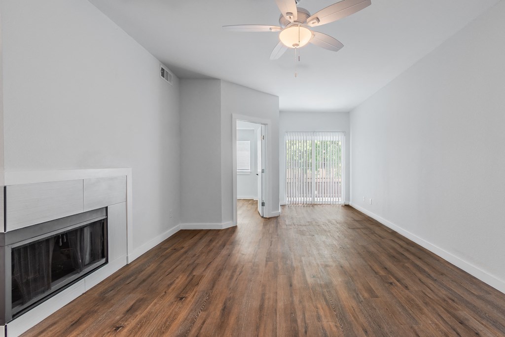 a living room with a fireplace and a ceiling fan