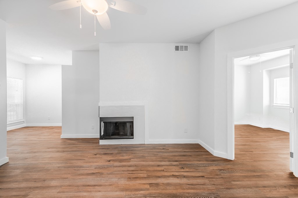 an empty living room with white walls and a fireplace
