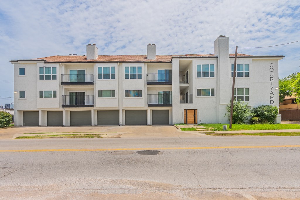 a white apartment building with a street in front of it