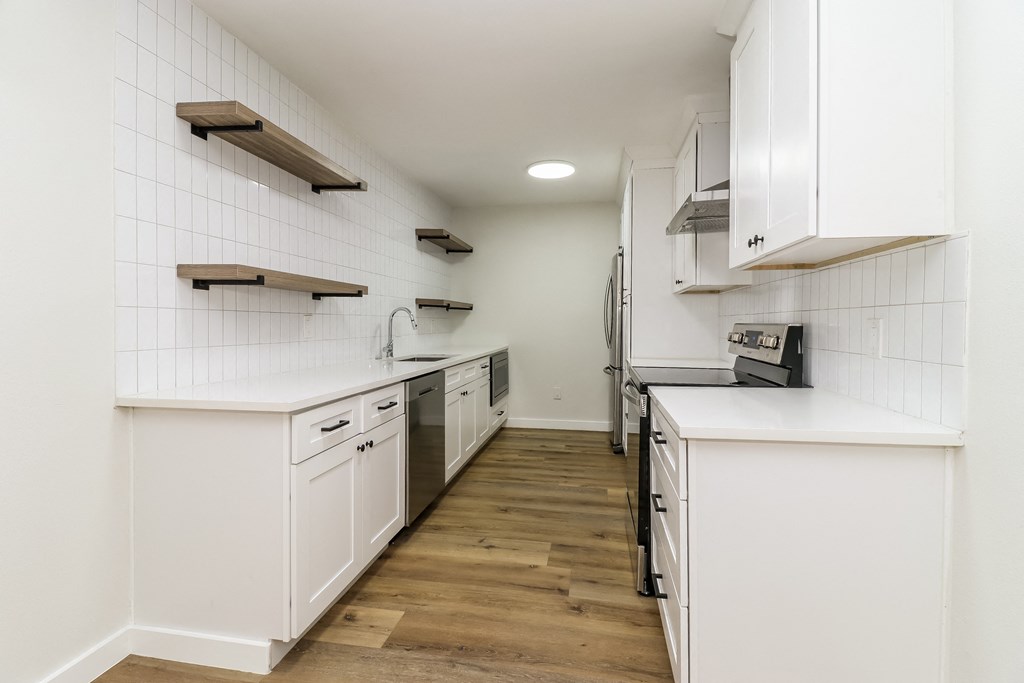 a kitchen with white cabinetry and a wood floor