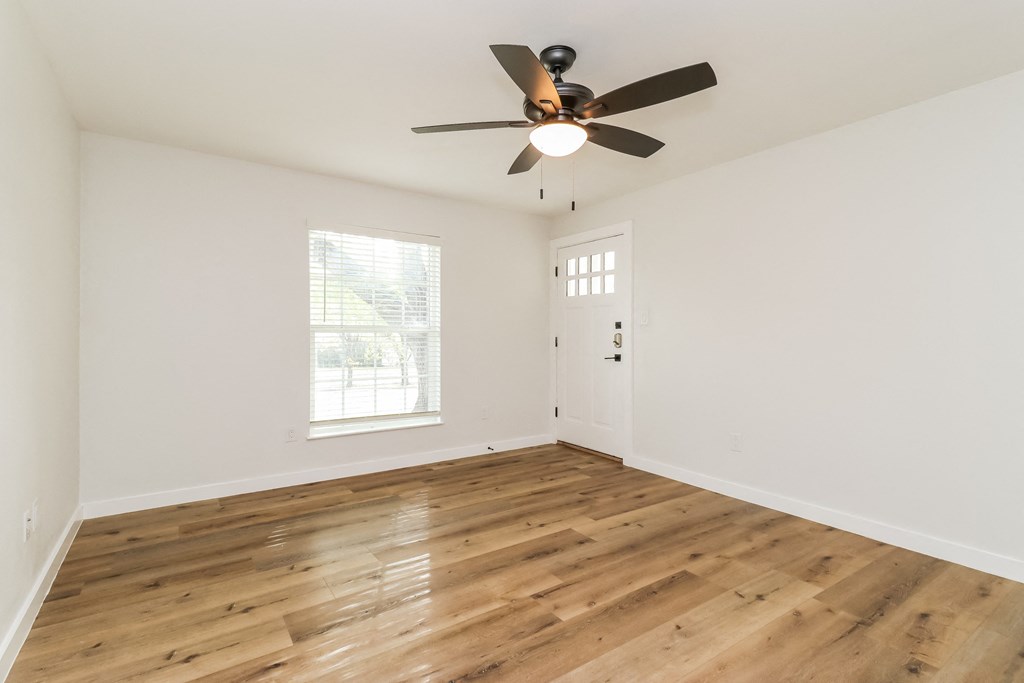a bedroom with hardwood floors and a ceiling fan