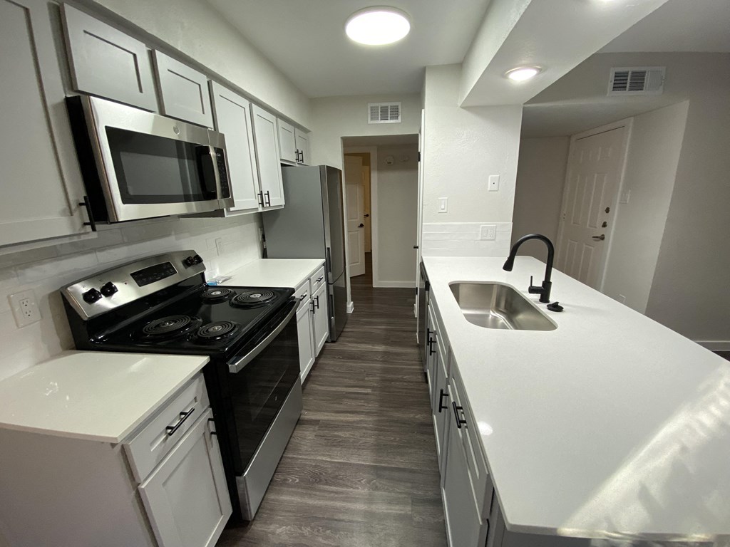 A kitchen with white cabinets and a black stove top oven.