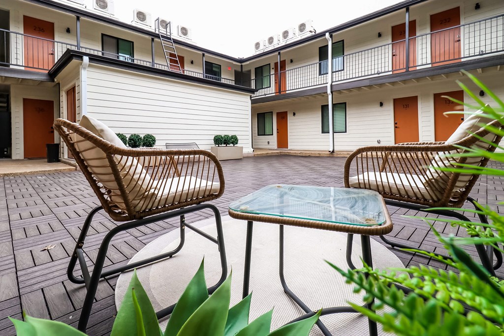 Exterior building area a patio with two chairs and a table at The Eastern Apartments, Dallas